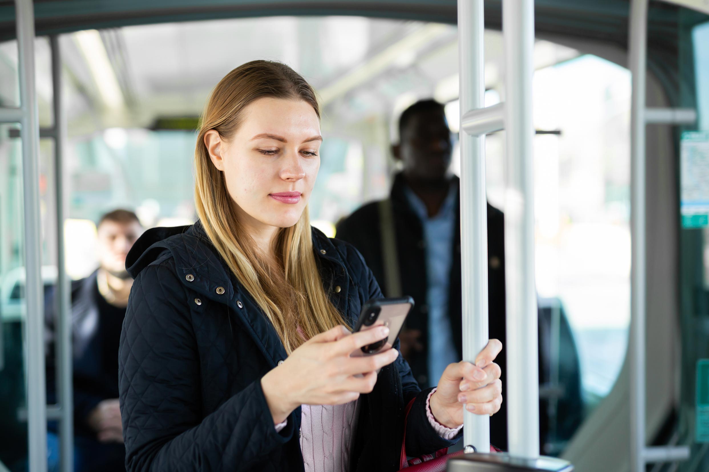 vrouw in tram kijkt op haar mobiel